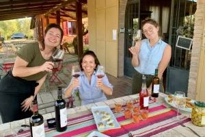 Chicca and guests tasting red and white wine acompanied by food served at Chiappini Winery (Bio)
