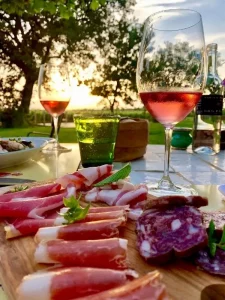 Glasses filled with cool rose wine coupled with plates of prosciutto and sussages - Guado al Tasso Wine Estate in Bolgheri Tuscany