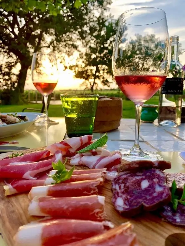 Glasses filled with cool rose wine coupled with plates of prosciutto and sussages - Guado al Tasso Wine Estate in Bolgheri Tuscany Glasses filled with cool rose wine coupled with plates of prosciutto and sussages - Guado al Tasso Wine Estate in Bolgheri Tuscany