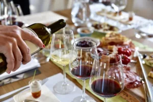 Pouring white and red wine in glasses at Chiappini Winery (Bio)