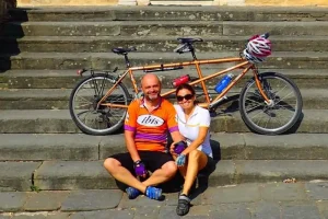 Chicca and Arnaud on stairs resting after riding a tandem bicylce