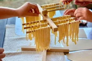 Guests hanging fresh made pasta to dry before cooking